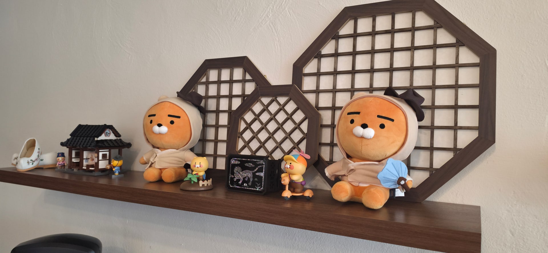 나무 창살 장식과 한옥 모형, 캐릭터 인형을 올린 선반